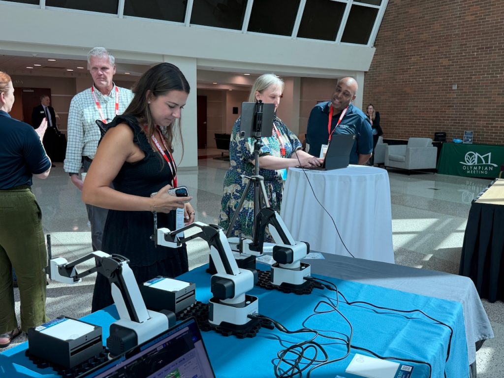 Conference attendees gathered around the LineBot Studios booth and iPad photo capture station